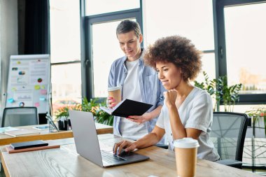 Çeşitli meslektaşlar bir dizüstü bilgisayarda işbirliği içinde çalışırlar..