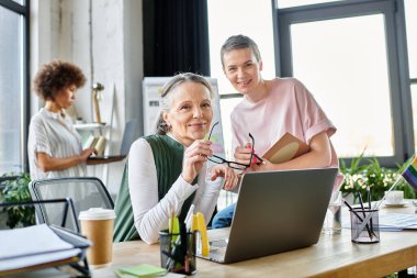 Merry diverse female professionals working together on their project in office. clipart