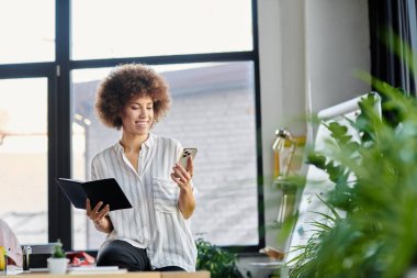 İş kadını masasında cep telefonunu kontrol ederken derin düşüncelere dalmış..