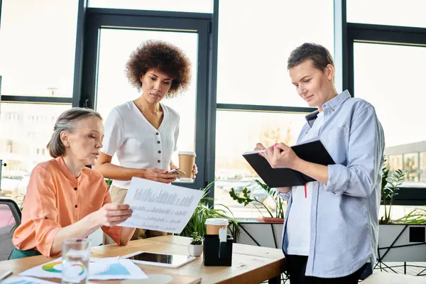 stock image Diverse group of hard-working businesswomen sharing ideas around a table in a coworking space.