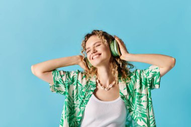 Kulaklıklı kadın mavi arka planda müzik dinliyor..