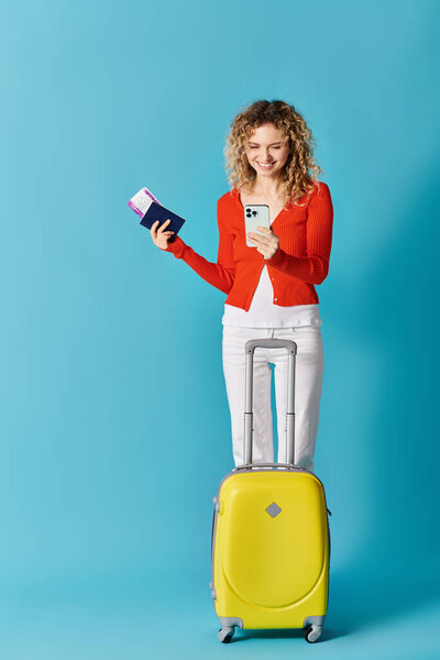 Woman with yellow suitcase and cell phone
