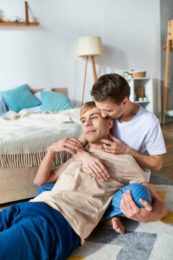 Two men lying comfortably together on the floor at home. clipart