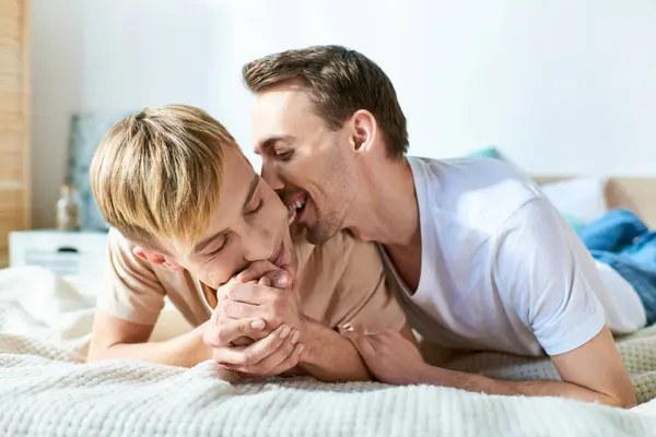 stock image Two men, a loving gay couple, laying on top of a bed together.