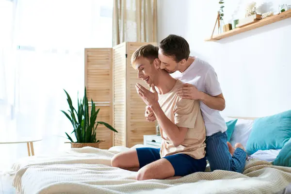 stock image Two men in casual attire sitting peacefully on a bed.