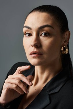 Siyah gömlekli zarif bir kadın fotoğraf için kendine güvenerek poz veriyor..