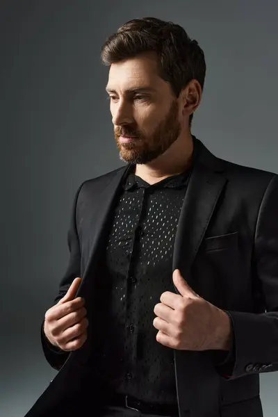 stock image A man in a stylish black suit and tie, exuding sophistication.