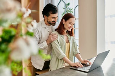 Modern apartment setting, woman and man bonding over laptop together. clipart