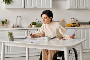 A disabled woman in a wheelchair sits at a table, near cup of coffee and working in a cozy home kitchen setting. clipart