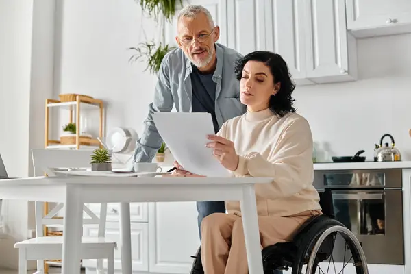 Man Wheelchair Woman Examining Document Cozy Kitchen Setting Home — Stock Photo, Image