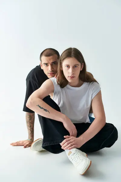 stock image Two men sitting intimately on the ground