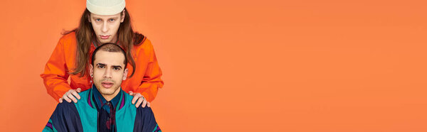 A man standing on top of his boyfriends head in a captivating display of balance and strength.