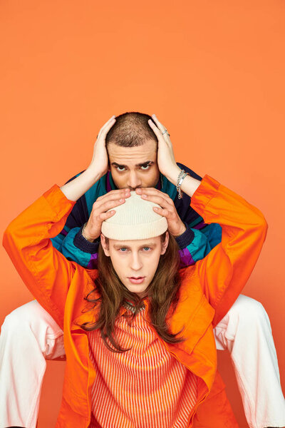 Мужчина с радостью сидит на стуле рядом с другим человеком.