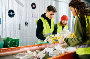 Two young women in yellow vests and gloves sorting garbage in a sustainable effort.