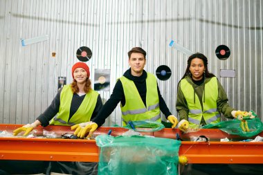 Young volunteers in yellow safety vests sorting trash at a table.