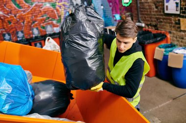 A young volunteer in a yellow vest holding a black bag, sorting trash with eco-conscious people.