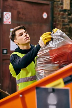 A man wearing a yellow vest holding a bag of waste