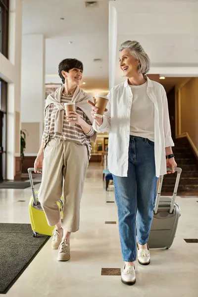 Två Äldre Lesbiska Partners Strosar Genom Flygplats Med Sitt Bagage — Stockfoto