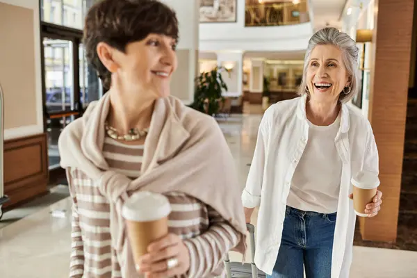 Two Women Enjoying Stroll Mall While Holding Coffee Cups — Fotografia de Stock