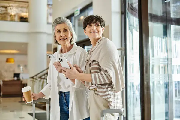 Senioren Lesbisch Paar Delen Een Liefdevol Moment Een Hotel Lobby — Stockfoto