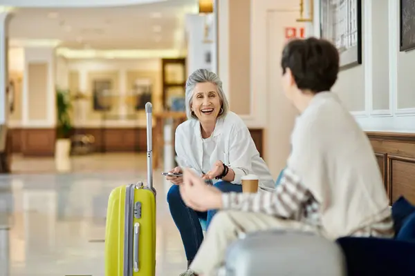 Senior Lesbian Couple Sits Yellow Suitcase Couch — Stock Photo, Image