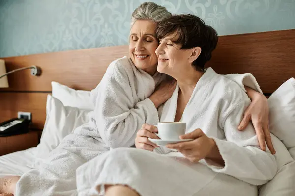 Two Senior Lesbians Robes Share Tender Moment Bed One Holding — Zdjęcie stockowe