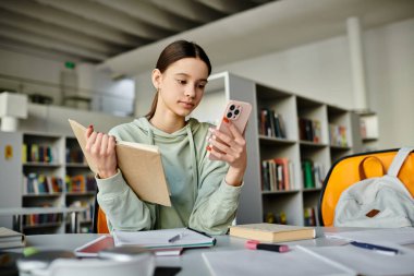 A teenage girl sits at a desk, engrossed in her phone after school, surrounded by books and a laptop. clipart