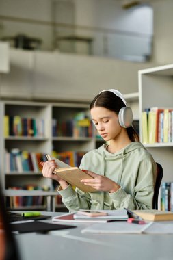 A teenage girl immersed in a book, wearing headphones, studying in a library after school. clipart