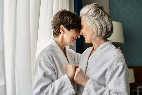 stock image Tender senior lesbian couple standing together in a hotel.