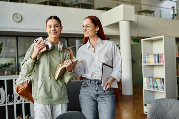 Рыжая женщина преподает девочке-подростку в библиотеке, обе держат книги, увлекшись уроками после школы