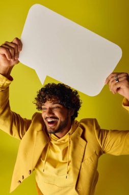 Kafasının üstünde konuşma balonu olan canlı kıyafetli yakışıklı Hintli adam..