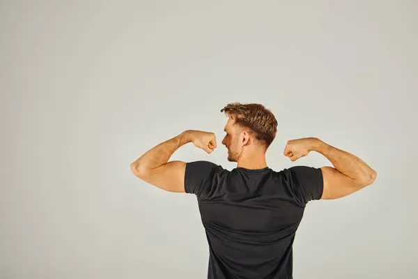 Young Athletic Man Flexes His Muscles Front White Background Showcasing — Stockfoto