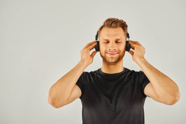 Kendi dünyasına dalmış, kulaklıkla müzik dinleyen bir adam..