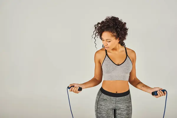 Curly African American Sportswoman Active Wear Holding Skipping Rope Front — Zdjęcie stockowe