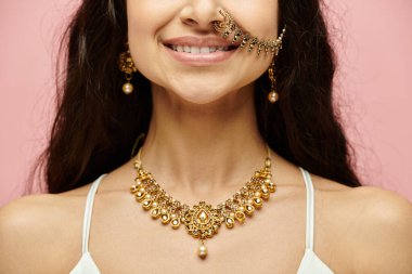 A young indian woman with gold jewelry and a nose ring posing elegantly clipart