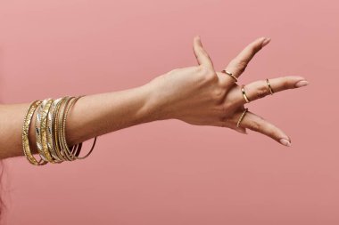 indian woman showcasing gold bangles on her hand in a stylish pose. clipart