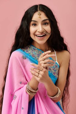 Canlı sari giymiş gülümseyen Hintli kadın mutlu poz veriyor..