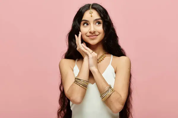 stock image Beautiful indian woman striking a pose against a vibrant pink backdrop.