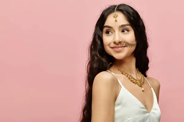 stock image Young indian woman with long hair strikes a pose against a vivid pink background.