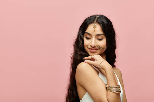 Красивая молодая индийская женщина позирует на ярком розовом фоне.
