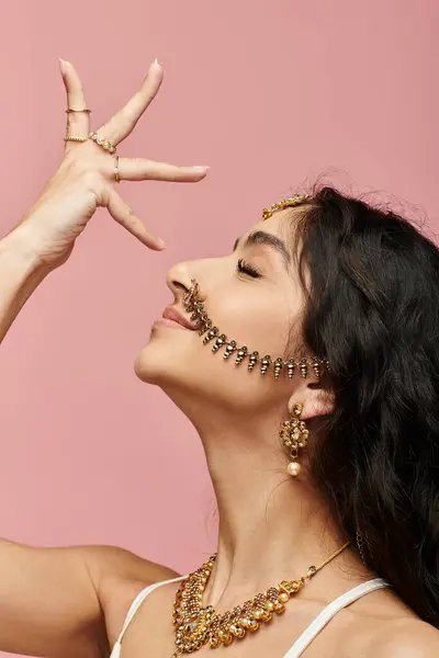 Stock image A stylish young indian woman flaunting a gold necklace and earrings.