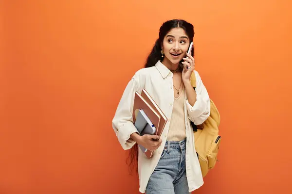 Young Indian Woman Energetically Conversing Cell Phone Bold Orange Backdrop — Foto Stock