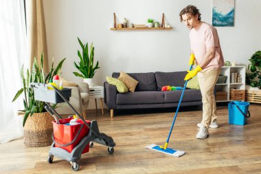 A stylish man in cozy homewear meticulously mops the floor. clipart