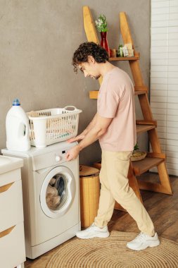 Ev elbiseli bir adam çamaşır makinesini dolduruyor..