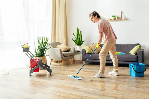 stock image Man in action, mopping living room floor with a mop.