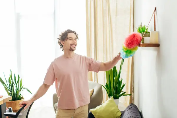 stock image Handsome man in cozy homewear holding a colorful duster.