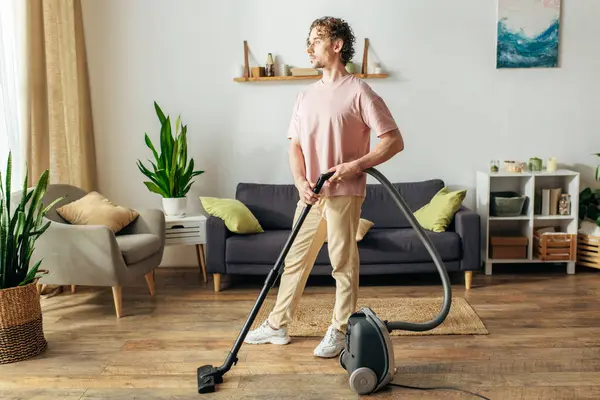 Handsome Man Cozy Homewear Diligently Vacuums Living Room Royalty Free Stock Photos