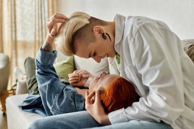 Kısa saçlı iki kadın sıcak bir koltuğa oturur, sevgi dolu bir kucaklaşmayla bağlantının güzelliğini gösterirler..