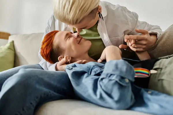一对短头发的女同性恋夫妇在舒适的沙发上亲切地拥抱在一起 — 图库照片