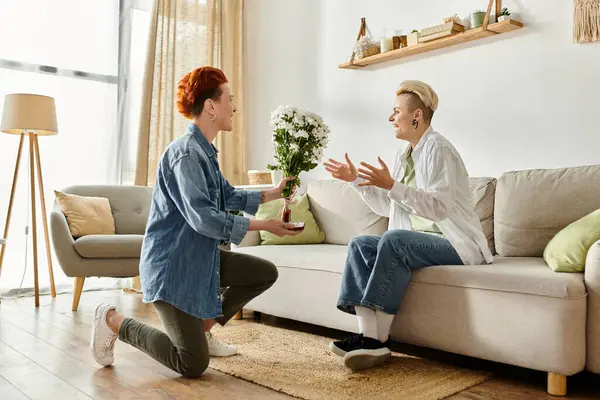 Woman Presents Flowers Her Partner Sitting Couch Home Making Marriage — Stockfoto